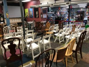 Mismatched chairs face a screen in an store